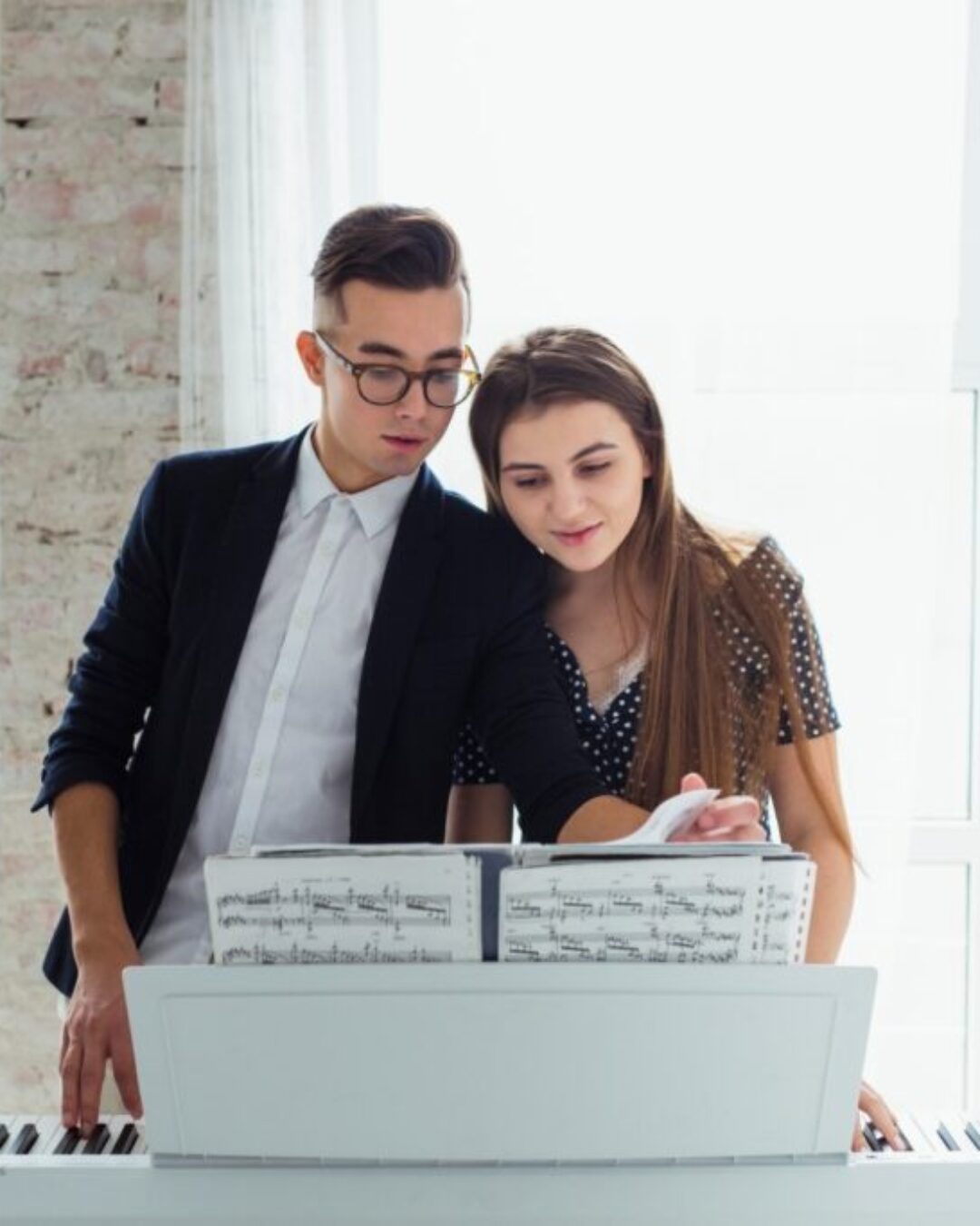 portrait-of-young-couple-looking-at-musical-sheet-learning-to-play-the-piano El reto de estudiar canto a distancia